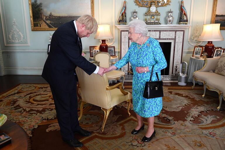 La reina Isabel II saluda al primer ministro Boris Johnson, tras asumir el cargo en 2019. (AFP)