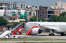 Avión Boeing 787-9 de Air India estacionado en aeropuerto, con escalera móvil y vehículos de apoyo visibles.