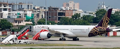 Avión Boeing 787-9 de Air India estacionado en aeropuerto, con escalera móvil y vehículos de apoyo visibles.