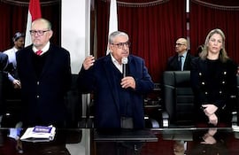 Isaías Ricardo Fretes con suéter oscuro y micrófono, mientras Hassel Jiménez, con barba, y Cecilia Rodríguez, en saco negro, lo escuchan atentamente.