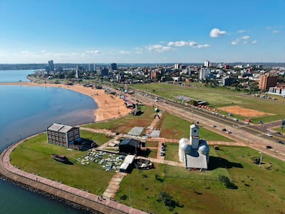 Panorama de la costa urbana de Asunción, con edificios emblemáticos junto al río Paraguay y áreas recreativas.