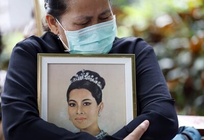 Una mujer tailandesa llora mientras sostiene una fotografía de la Reina Madre Sirikit tras el anuncio de su fallecimiento en el Hospital Memorial Rey Chulalongkorn de Bangkok,
