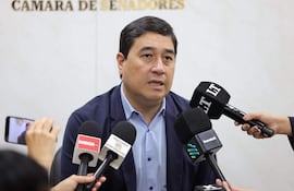 Eduardo Nakayama Rojas, en saco oscuro y camisa celeste, rodeado de periodistas con micrófonos en la Cámara de Senadores.