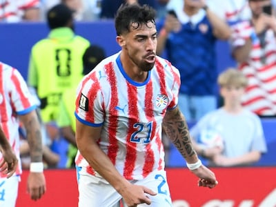 Gabriel Ávalos con camiseta roja y blanca, número 21, en estadio lleno, muestra expresión tranquila mientras juega.