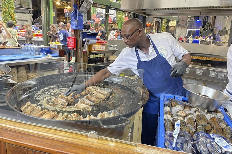 El mercado gastronómico de Borough, uno de los más populares de Londres, recibe a diario largas colas de visitantes para comprar una porción de paella en el puesto de arroces que causa furor entre los turistas y visitantes y donde se venden más de 1.000 raciones a diario. Son las diez de la mañana y huele a aceite de oliva, ajo, cebolla, pimiento y tomate rallado, el tradicional sofrito de paella. 