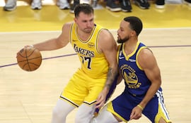 Luka Doncic (i) de Los Angeles Lakers disputando un balón con Stephen Curry de los Golden State Warrios en un partido de la NBA en Los Angeles, California (Estados Unidos). Las camisetas de Curry, base de los Golden State Warriors, y Doncic, escolta de Los Angeles Lakers, lideraron la lista de más vendidas al término de la temporada regular de la NBA.