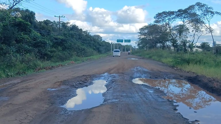 La carretera rural en zona de Correa Rugua presenta grandes charcos debido a baches inundados tras recientes lluvias.