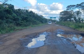 La carretera rural en zona de Correa Rugua presenta grandes charcos debido a baches inundados tras recientes lluvias.