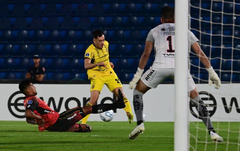 El mediapunta de Recoleta FC, Junior Noguera intenta el disparo ante la barrida del zaguero  Patricio Boolsen, del Deportivo Cuenca de Ecuador.