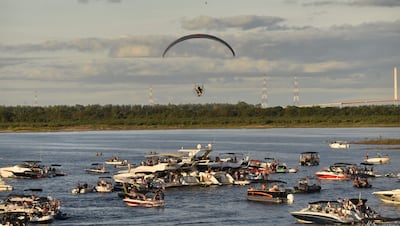 El parapente se desplaza sobre varias embarcaciones que fueron parte del festival flotante La Jangada, sobre el río Paraguay.