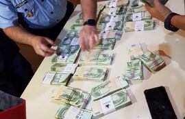 el-director-de-policia-del-departamento-de-amambay-crio-gral-victor-rivas-verifica-los-fajos-de-billetes-que-segun-la-precinta-fueron-retirados-213552000000-1787827.jpg