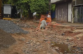 Vecina cruza las destruidas calles de Petereby y Baldomero Ruiz, en el barrio San Pablo, donde las lluvias causaron estragos en la zona de obras de desague pluvial de la cuenca Lambaré.