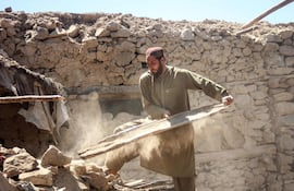 Un hombre retira escombros de una casa destruida por un bombardeo paquistaní en la localidad de Barolo, en la provincia afgana de Kunar.