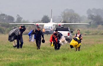 Momento en que el hijo de Cartes, Juampi (1º der.), regresa luego del salto realizado ayer desde C-212 de la Fuerza Aérea.