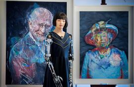 El robot artista humanoide ultrarrealista Ai-Da observa frente a los retratos del rey Carlos III y la reina Isabel II de Reino Unido, exhibidos al margen de la cumbre global “IA para el bien común” organizada por la Unión Internacional de Telecomunicaciones (UIT) en Ginebra, el 9 de julio de 2025.