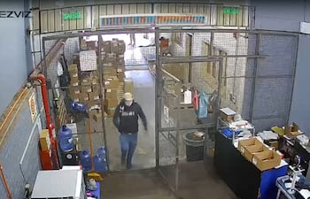 Momento en que uno de los asaltantes ingresa en el depósito para perpetrar el robo, tras mata al guardia.