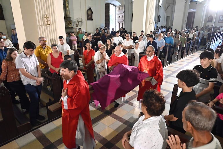Religiosos ingresan con la imagen de Cristo en la cruz, cubierta con un manto, como previa a la misa de Pascuas en la Catedral.