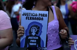 Una mujer sostiene un cartel durante una marcha como parte del Día Internacional de Eliminación de la Violencia contra la Mujer, en Asunción (Paraguay).