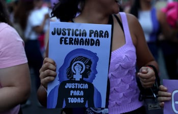 Una mujer sostiene un cartel durante una marcha como parte del Día Internacional de Eliminación de la Violencia contra la Mujer, en Asunción (Paraguay).