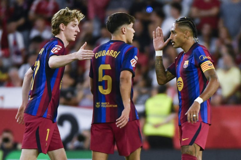 El delantero del FC Barcelona Raphinha (d) celebra con sus compañeros tras marcar el 1-1 durante el partido de LaLiga entre el Sevilla FC y FC Barcelona celebrado este sábado en el estadio Sánchez-Pizjuán de Sevilla.