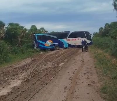 Autobús de San Juan S.R.L. atascado en barro, camino a Fuerte Olimpo