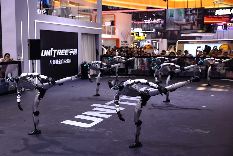 Asistentes observan a robots humanoides bailar durante un espectáculo en el puesto de Unitree Robotics, en el marco de la Conferencia Mundial de Robótica 2026, en Pekín, China, el 20 de agosto de 2026.