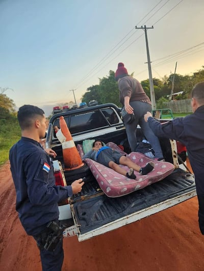 Niño recién nacido en patrullera con agentes de seguridad que ayudan, rodeados de vegetación y un camino de tierra.