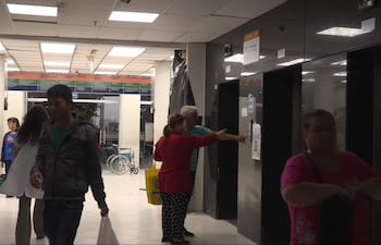 Una paciente del hospital, junto con su marido, intentan en vano usar uno de los ascensores, que está descompuesto.