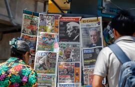 Lima, 14 de abril de 2025: la gente lee en las portadas de los diarios la noticia del fallecimiento de Mario Vargas Llosa en un quiosco en el cruce de las avenidas Aviación y Javier Prado, en San Borja (Renato Pajuelo / AFP)