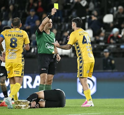 El árbitro Derlis Benítez exhibe la cartulina de amonestación al zaguero uruguayo, Agustín da Silveira, en el duelo entre Libertad y Sportivo Trinidense, disputado en el estadio La Huerta.