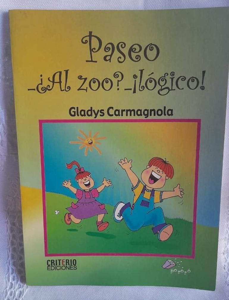 Portada del libro con un niño y una niña alegres, fondo colorido con cielo azul y sol sonriente.