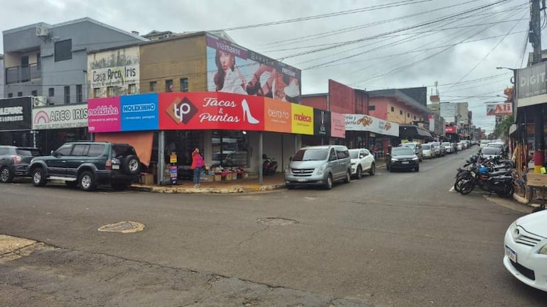 Calles urbanas de Encarnación con vehículos en movimiento y estacionados, mostrando establecimientos comerciales como Tacos & Puntas.