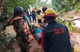Personal de salud y equipos de rescate asisten a personas afectadas tras el desbordamiento de un río este sábado, en El Torno (Bolivia).