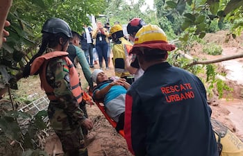 Personal de salud y equipos de rescate asisten a personas afectadas tras el desbordamiento de un río este sábado, en El Torno (Bolivia).