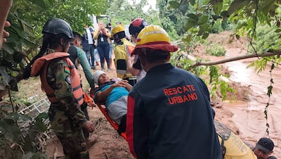Personal de salud y equipos de rescate asisten a personas afectadas tras el desbordamiento de un río este sábado, en El Torno (Bolivia).
