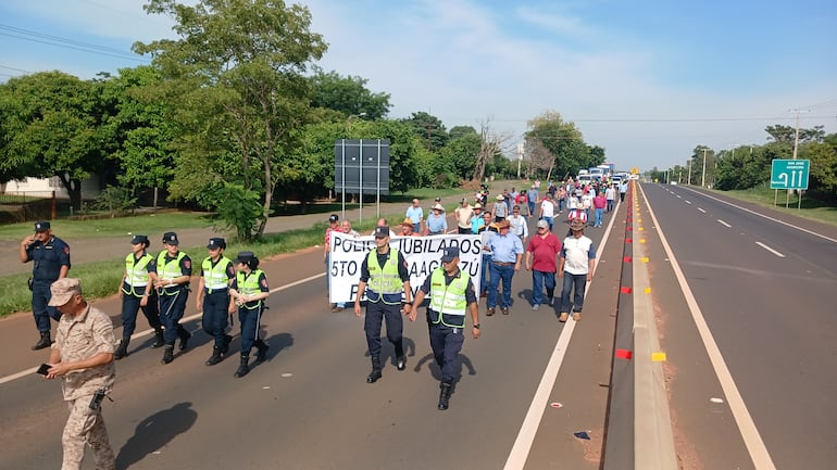 Policías jubilados marchan sobre la Ruta Py 02 en protesta por la reforma de la caja de jubilación.