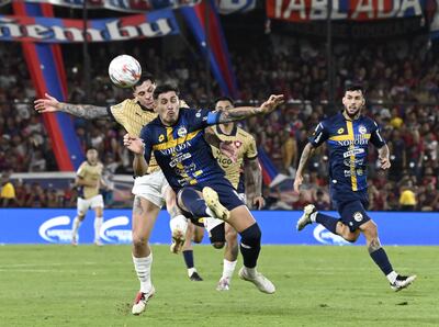 El zaguero de Sportivo Trinidense, Juan Ángel Vera despeja el balón ante la presión del delantero de Cerro Porteño, Juan Manuel Iturbe.