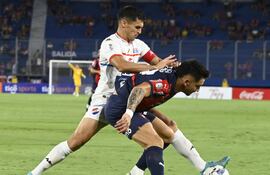 El argentino Jonathan Torres (d), futbolista de Cerro Porteño, protege el balón frente a la marca de Claudio Núñez, jugador de Nacional, en un partido de la tercera fecha del torneo Apertura 2025 del fútbol paraguayo en el estadio La Nueva Olla, en Asunción, Paraguay.