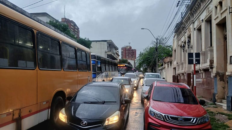 La congestión de vehículos en una jornada nublada muestra un autobús amarillo y coches en la calle Azara.