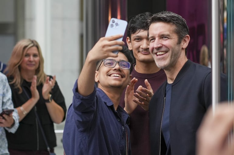El actual director general de Apple, John Ternus (d), se toma una fotografía con un seguidor en la entrada de la tienda de Apple durante el lanzamiento del iPhone 18 Pro y Pro Max este viernes, en Manhattan, Nueva York (Estados Unidos). 