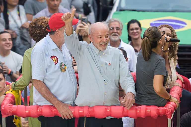 Brazil's President and presidential candidate Luiz Inacio Lula da Silva (C) gestures next to First Lady Rosangela Janja da Silva (R) during a campaign rally in Belo Horizonte, Minas Gerais state, Brazil on October 2, 2026. Brazilians go to the polls on October 4, 2026, in a tight race led by leftist President Luiz Inacio Lula da Silva and right-wing senator Flavio Bolsonaro, son of former president Jair Bolsonaro. (Photo by Gledston Tavares / AFP)