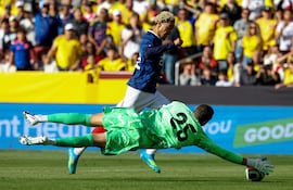El portero colombiano Álvaro Montero, número 25, realiza una parada ante un ataque del delantero francés Hugo Ekitike, número 22, durante un partido amistoso de fútbol entre Colombia y Francia en el Northwest Stadium de Landover, Maryland, el 29 de marzo de 2026. (Foto de FRANCK FIFE / AFP)