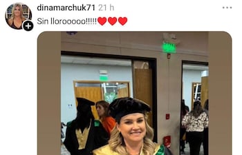 Dina Marchuk sonríe mientras sostiene su certificado de doctorado de la Universidad Columbia vestida con toga negra y birrete, en un ambiente festivo.