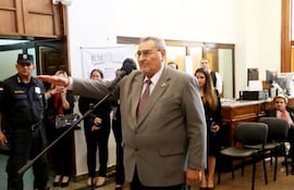 Antonio Fretes, con traje gris, gesticula mientras habla ante un micrófono; un público atento observa.