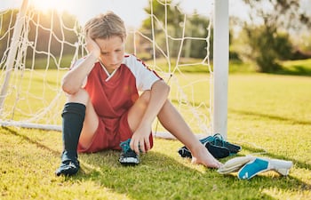 Niño triste tras la derrota en un juego deportivo, imagen ilustrativa.