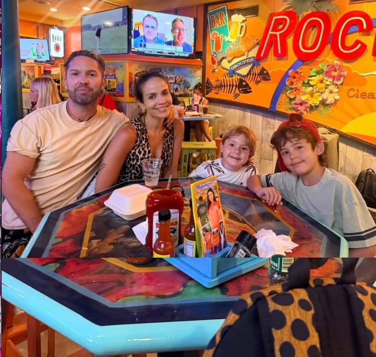 Roberto Ruiz Díaz sonríe junto a Antonella Volpe y sus hijos, en un restaurante colorido y familiar con mesas llenas de salsas.