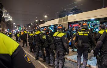 Agentes de policía establecen un cordón de seguridad alrededor de un autobús después del partido de fútbol entre Ajax y Maccabi Tel Aviv, en Ámsterdam, Países Bajos, en la madrugada del 8 de noviembre de 2024.