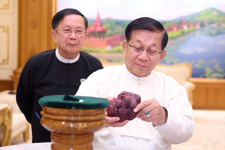 Esta fotografía de archivo, tomada y difundida el 7 de mayo de 2026 por Myanmar Radio and Television (MRTV), muestra al líder del golpe de Estado y presidente de Myanmar Min Aung Hlaing (der.) sosteniendo un rubí de 11.000 quilates en Naypyidaw, tras haber sido hallado en un yacimiento de gemas en Mogok, en la región de Mandalay.