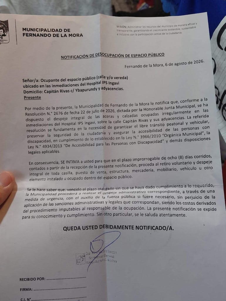 Notificación oficial impresa de la Municipalidad de Fernando de la Mora sobre desocupación de espacio frente al Hospital IPS Ingavi.