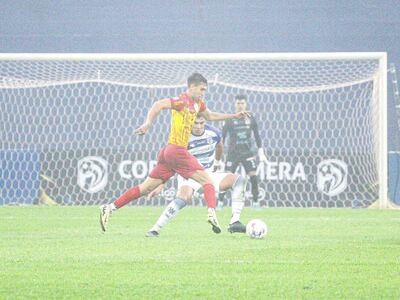 Avance de Mathías León ante la cobertura defensiva de Pedro Sosa, en una acción registrada en medio de la neblina.